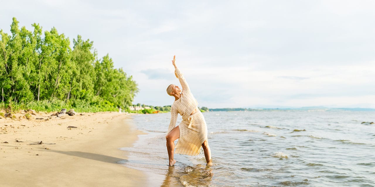 Align Cycling Founder, Sarah DeGray, doing yoga on a beach.